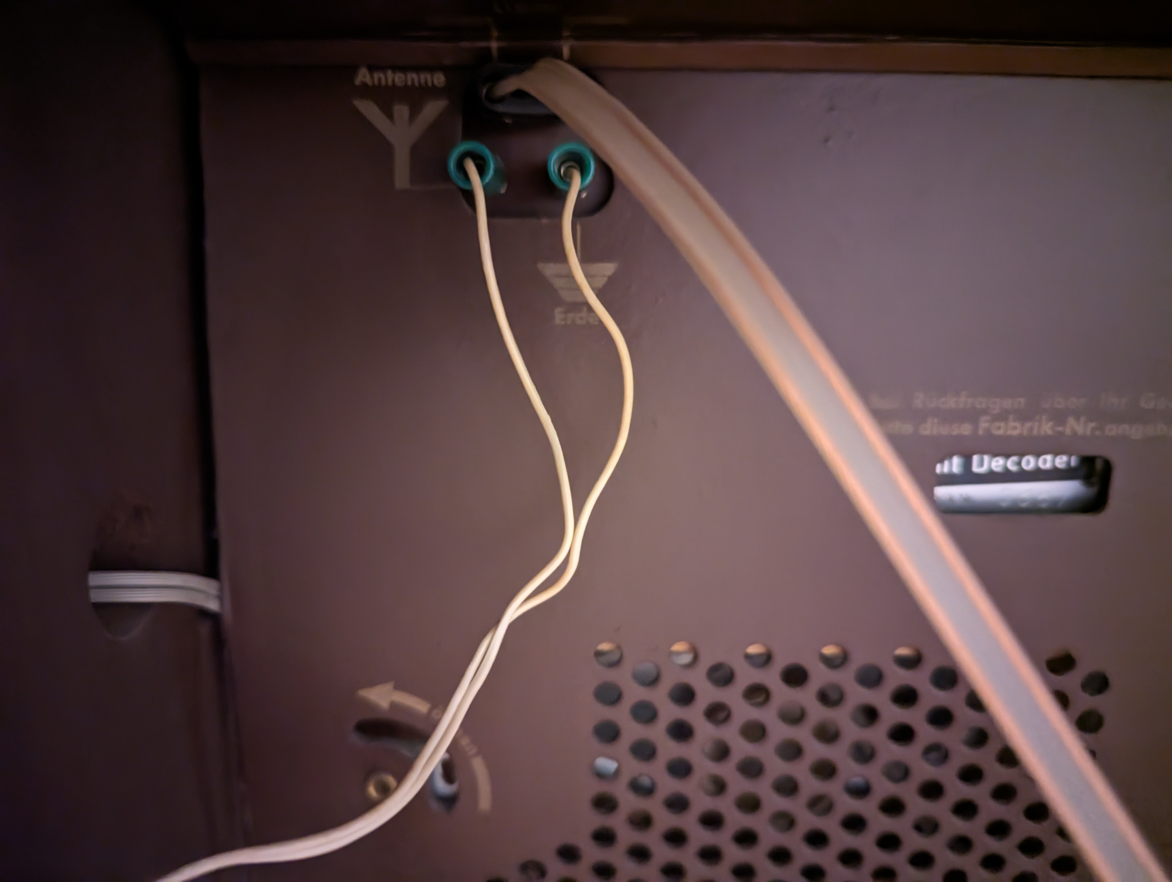 The backside of the appliance showing two connectors. One is labelled"Antenne" and the other"Erdung". The latter has two male connectors attached to cables plugged in.