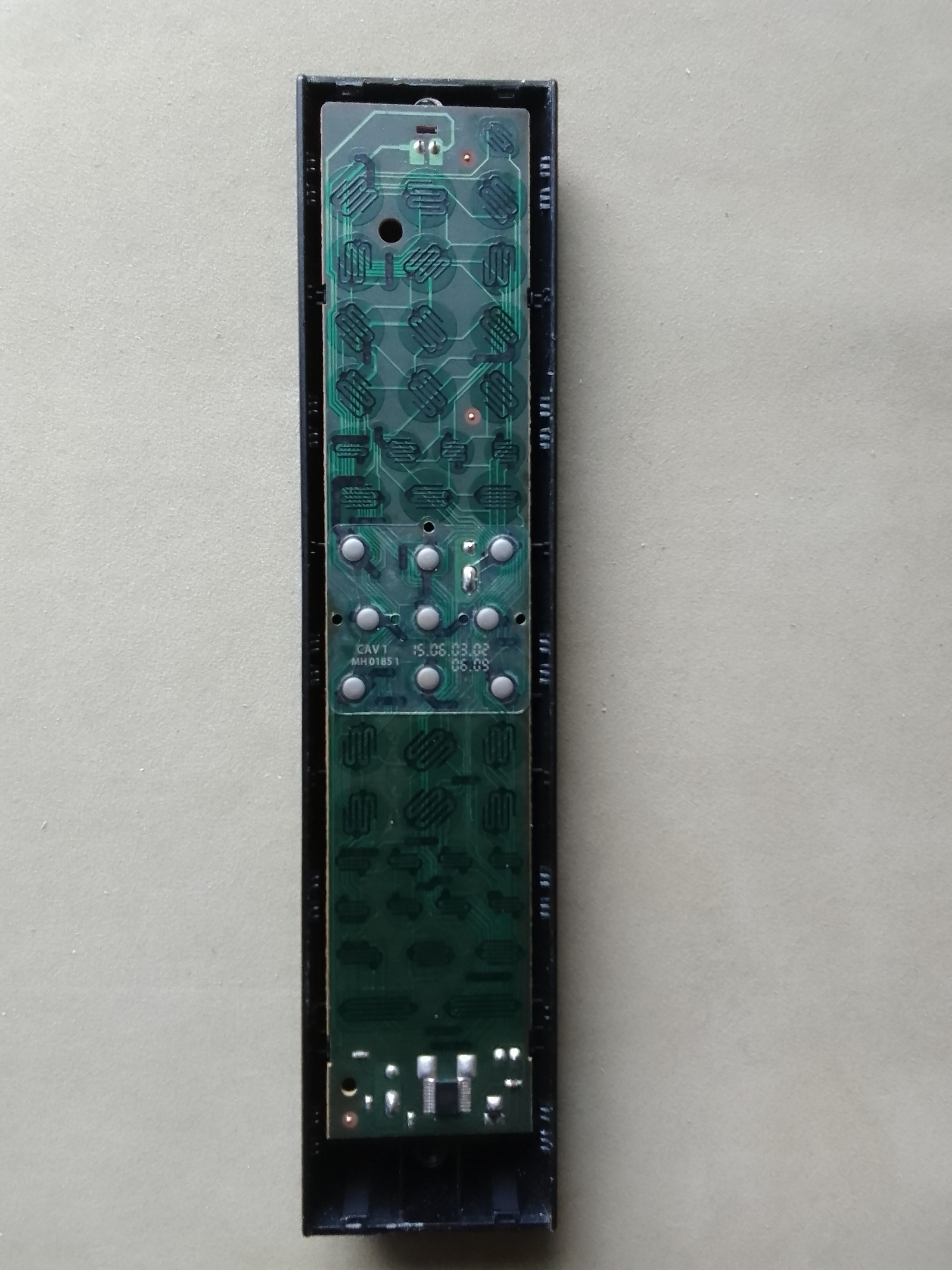 Photo of the board of the remote control. In the centre are 9 round silver buttons